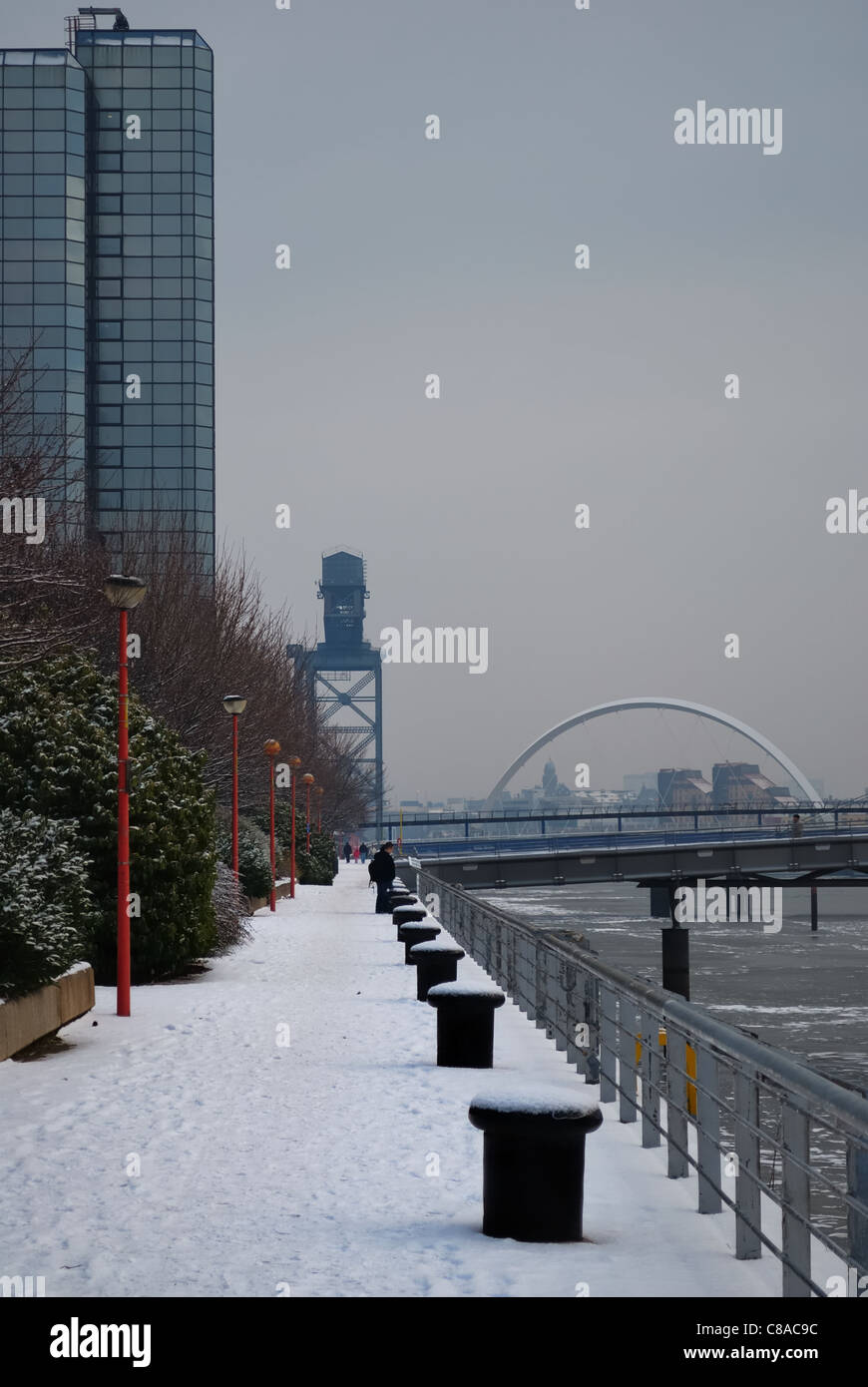 Snow covered walkway on the river Clyde near Glasgow city centre in Scotland, UK,on a very grey day. Stock Photo