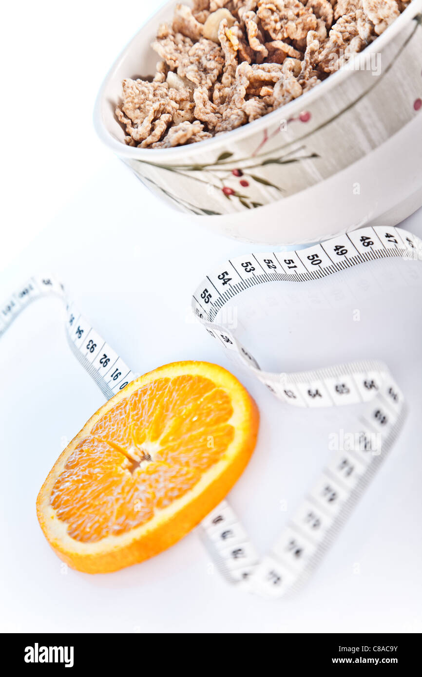 slice of orand , bowl of cornflakes and measuring tape Stock Photo