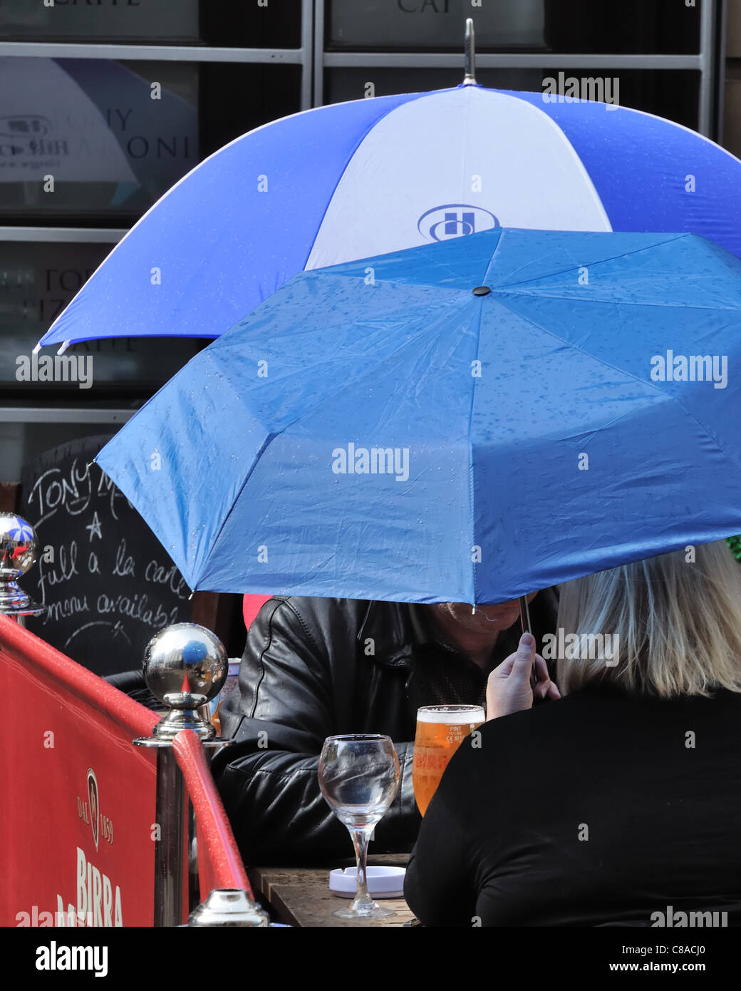 People having drinks in the rain. Stock Photo