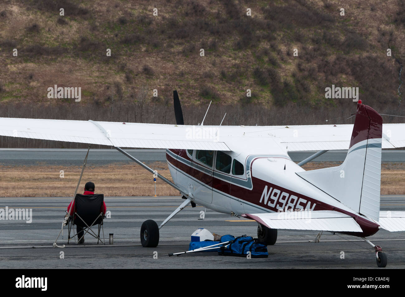 Man sits by his plane, Valdez Flyin and Air Show, Valdez, Alaska Stock