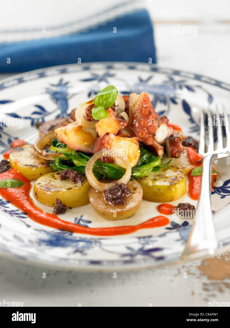 Octopus with potatoes,young turnips and red pepper puree Stock Photo