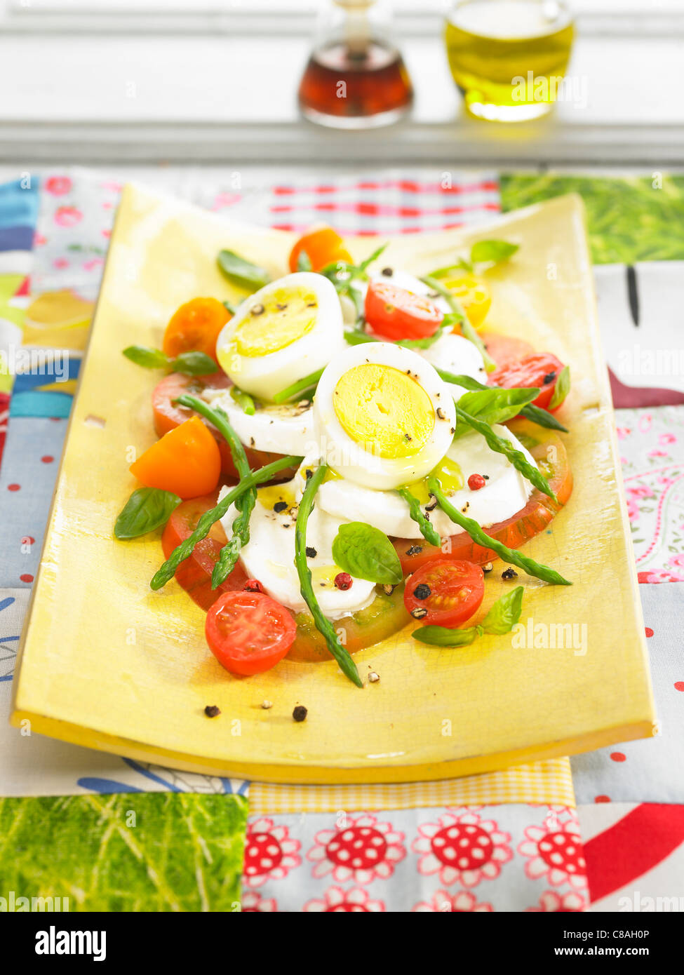 Tomato,mozzarella,hardboiled egg and green asparagus salad Stock Photo
