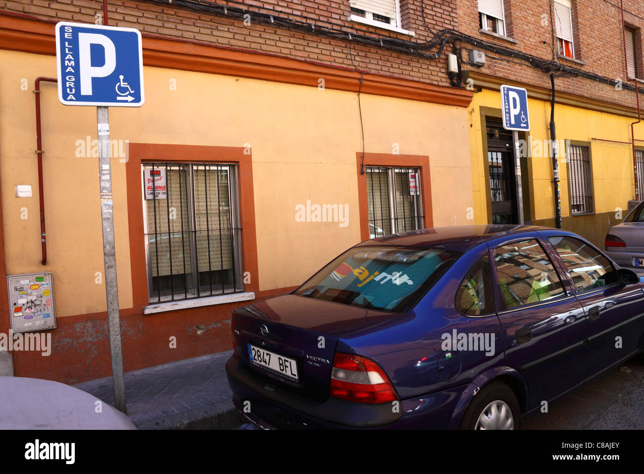 Cars parked in front of disabled parking signs in typical suburb , Carabanchel district , Madrid , Spain Stock Photo