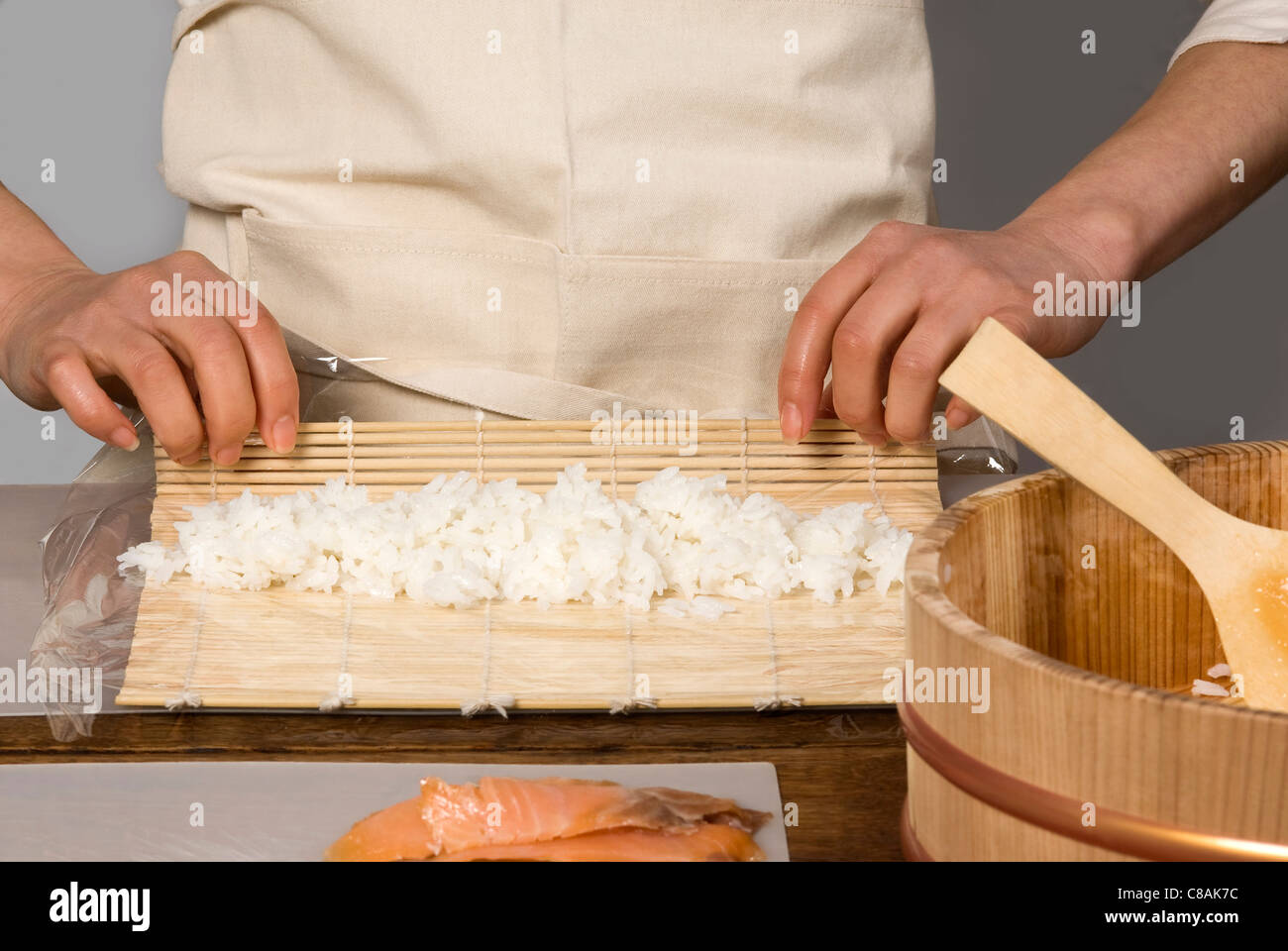 Cook rolling the rice in a mat for makis Stock Photo