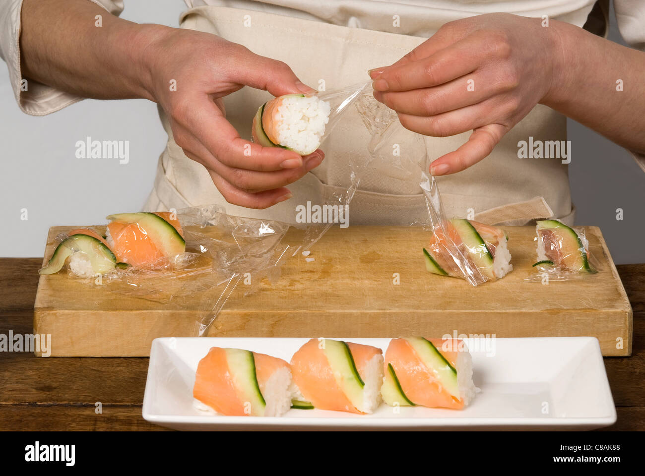 Cook preparing salmon and cucumber makis Stock Photo