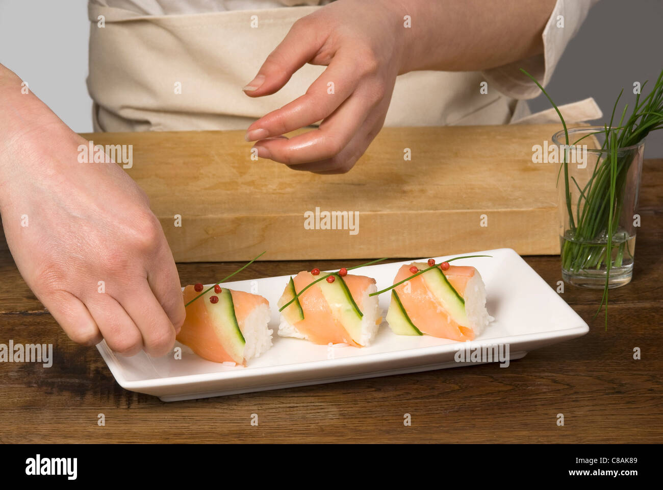 Cook preparing salmon and cucumber makis Stock Photo