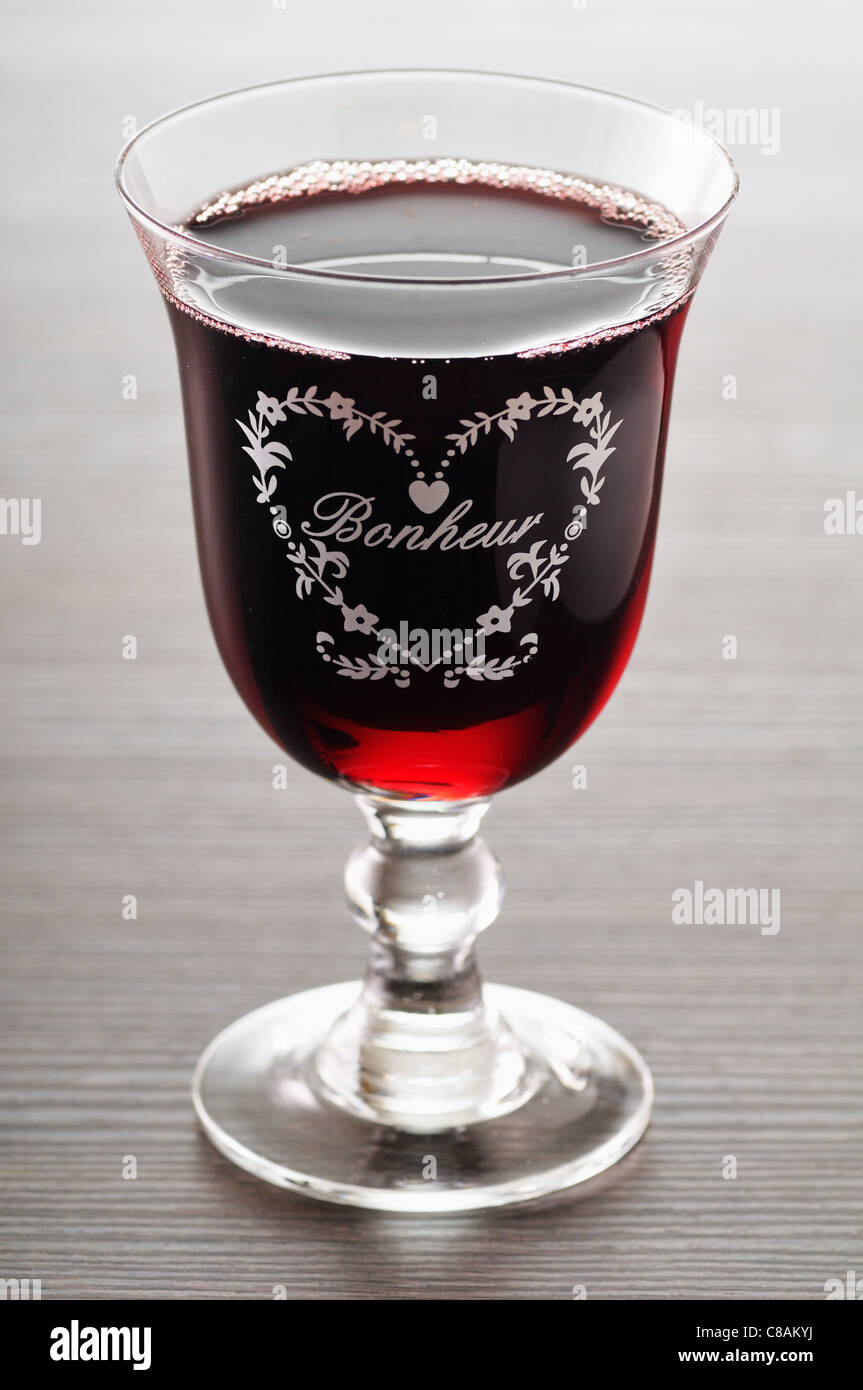 Bonheur engraved on a glass of red wine Stock Photo