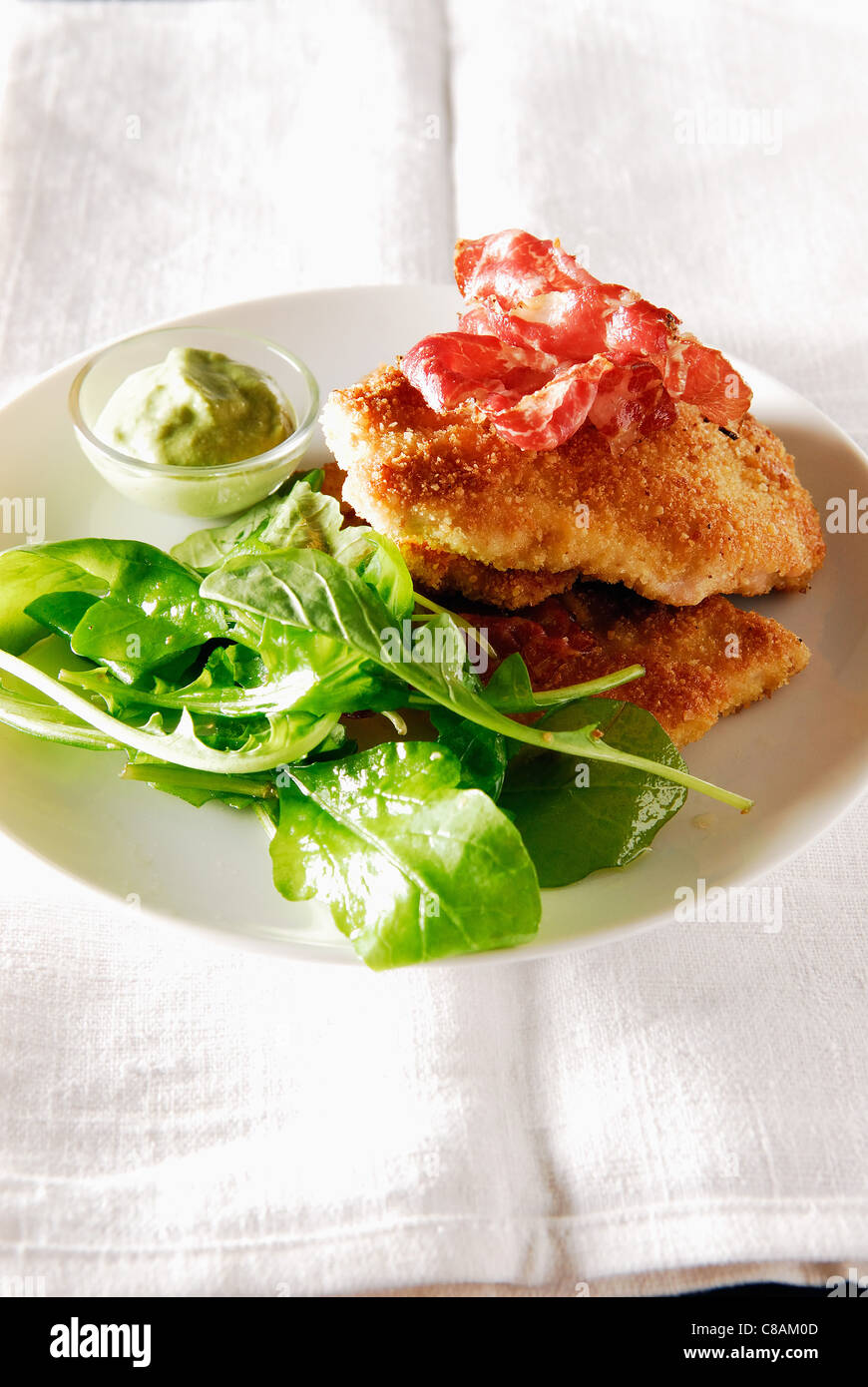 Breaded escalope with mozzarella and raw ham,rocket and spinach salad ,tarragon sauce Stock Photo