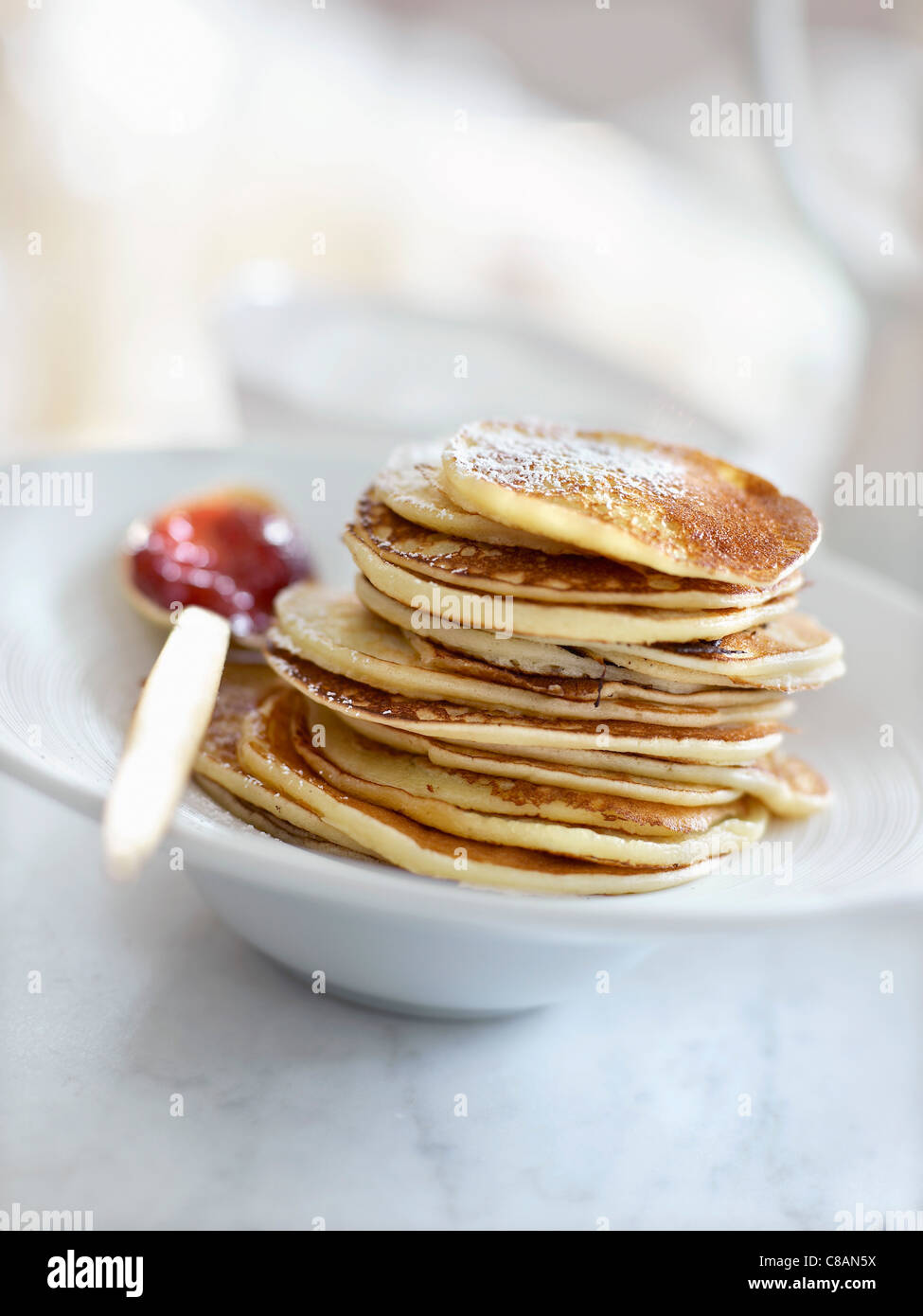 Stacked pancakes and a spoonful of summer fruit jam Stock Photo