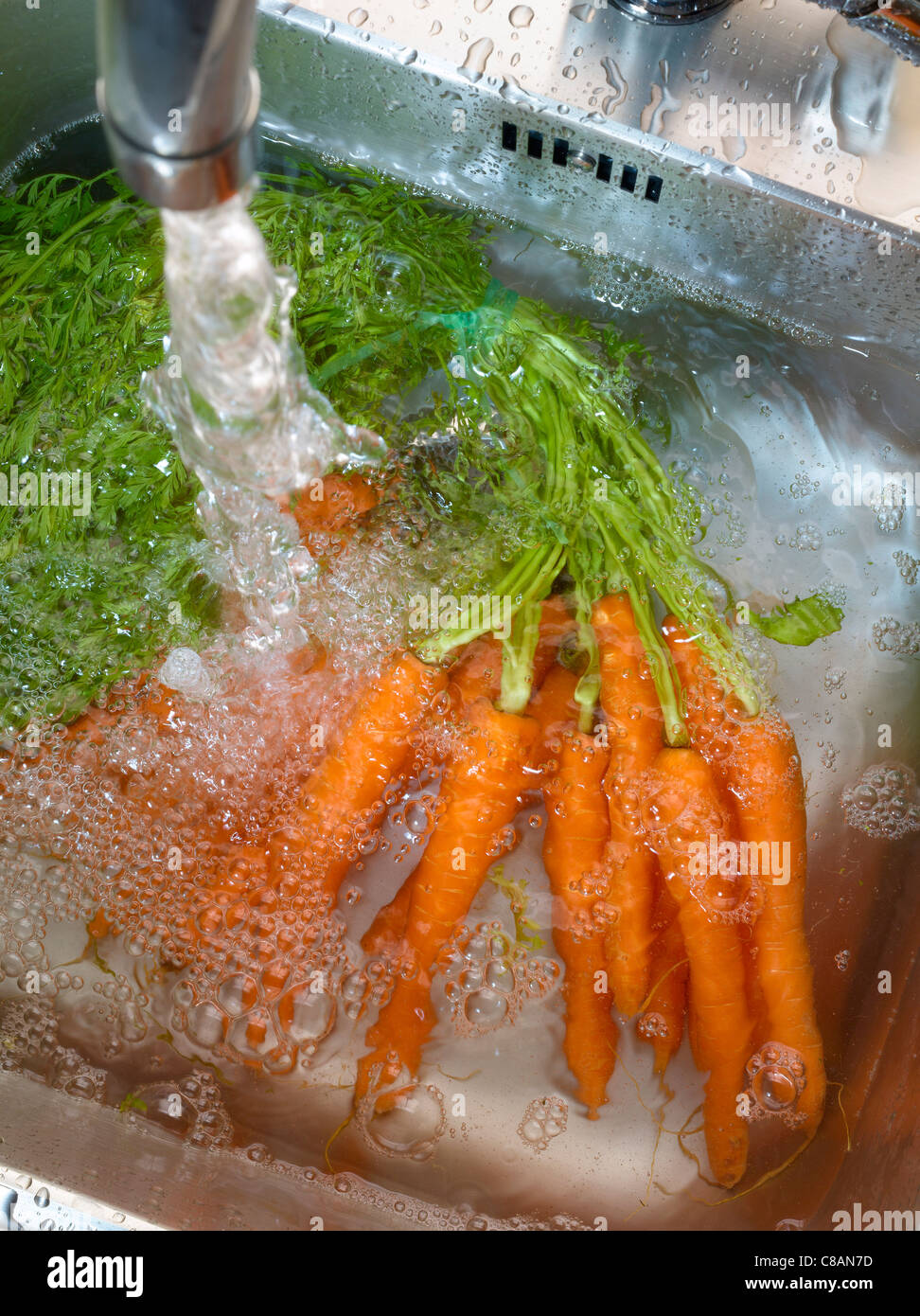 Washing carrots in the sink Stock Photo Alamy
