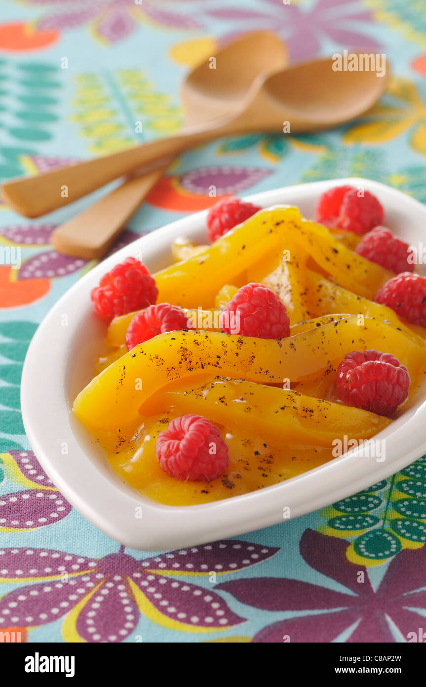 Stewed mangoes with fresh raspberries ,honey and vanilla Stock Photo