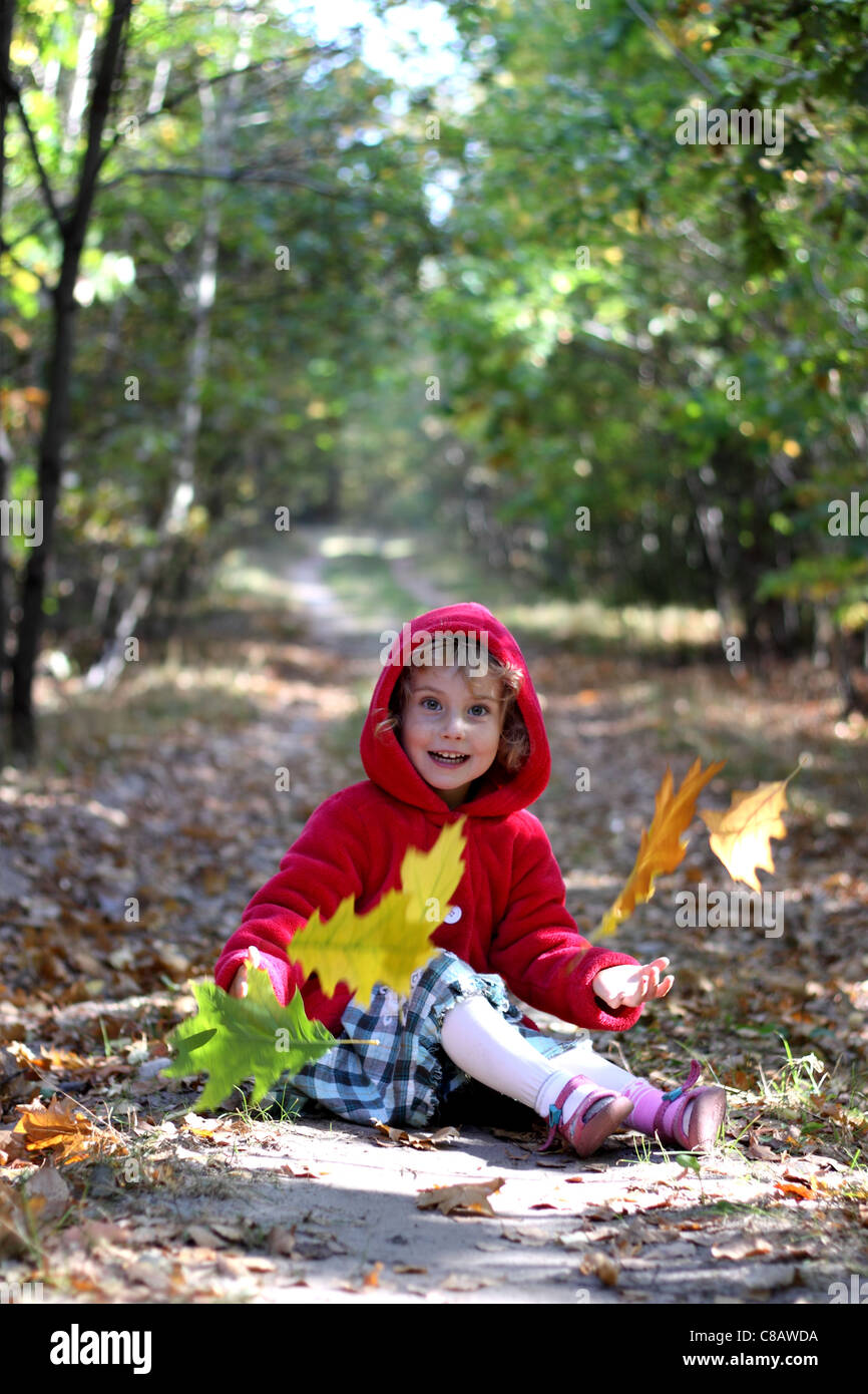 The little girl in a red cap in the autumn forest Stock Photo - Alamy
