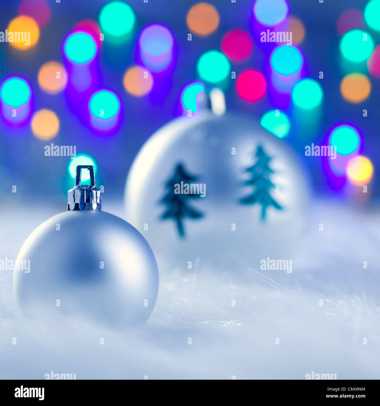 christmas silver baubles witn tree and burred lights background Stock ...
