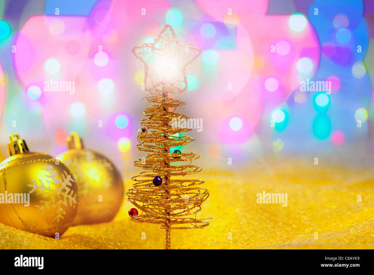 Christmas golden tree with baubles in blur lights background Stock ...