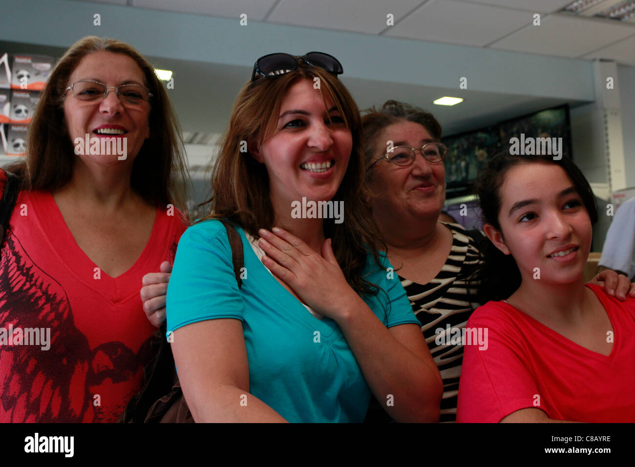 Israeli women in a warehouse shop reacting to a television broadcast of first pictures of Israeli soldier Gilad Schalit freed in prisoner swap deal on 18 October 2011. The Islamist group Hamas has freed Israeli soldier Gilad Shalit from more than five years in captivity. Stock Photo