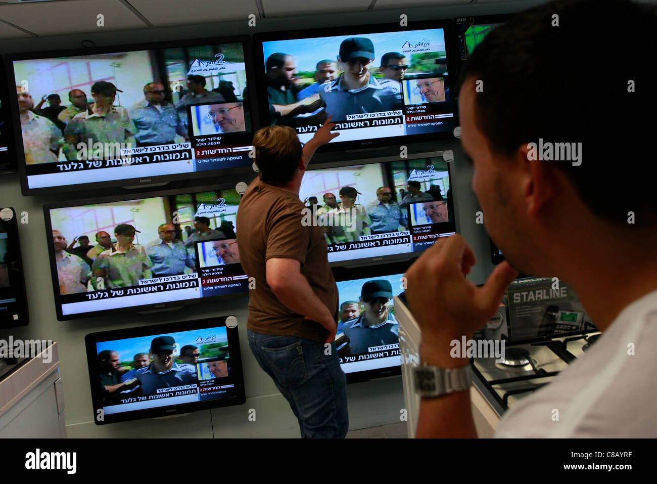 An Israeli man in a warehouse shop watch a television broadcast of first pictures of Israeli soldier Gilad Schalit freed in prisoner swap deal on 18 October 2011. The Islamist group Hamas has freed Israeli soldier Gilad Shalit from more than five years in captivity. Stock Photo