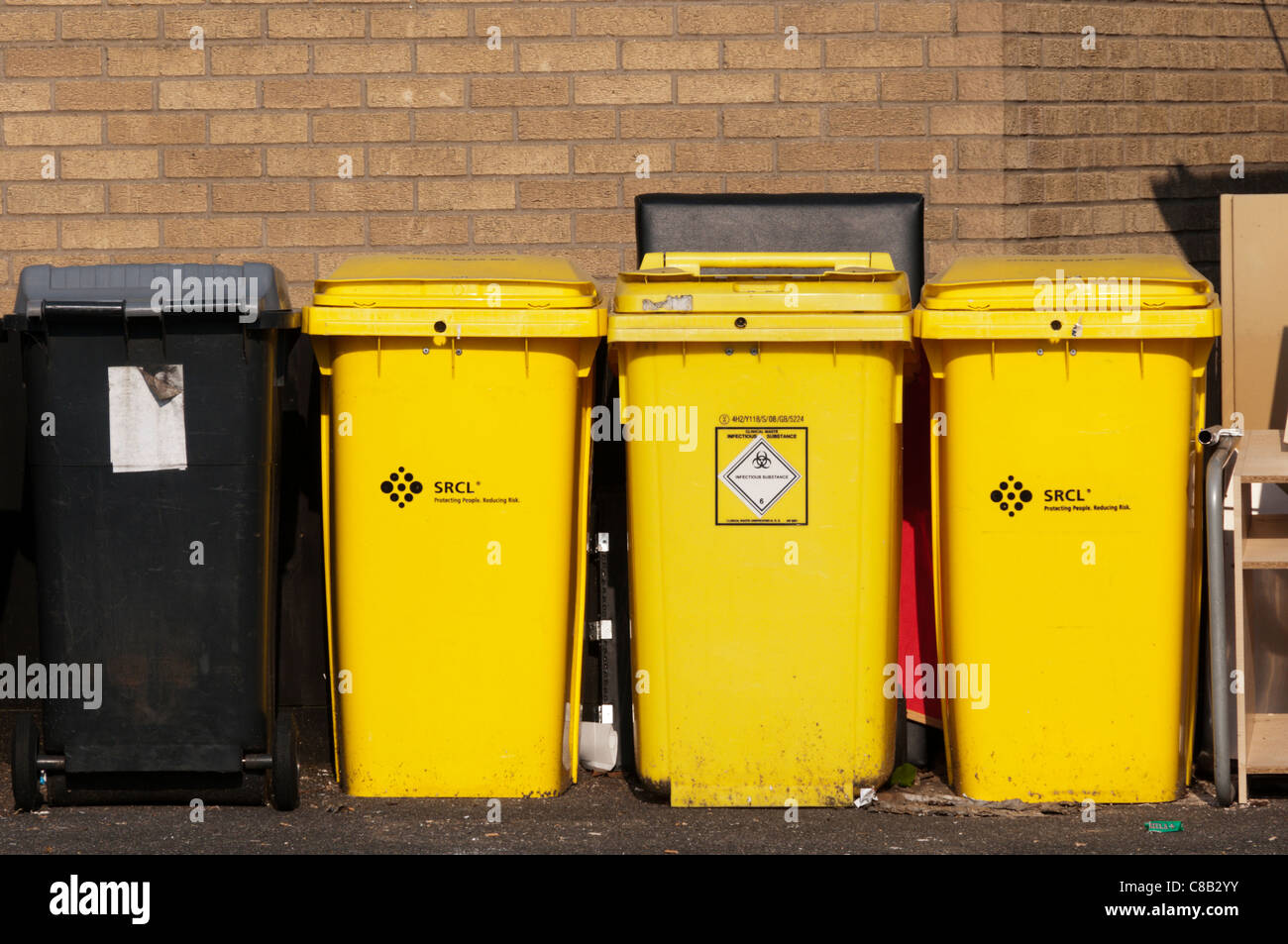 Yellow wheelie bins for clinical waste or infectious substances. Stock Photo