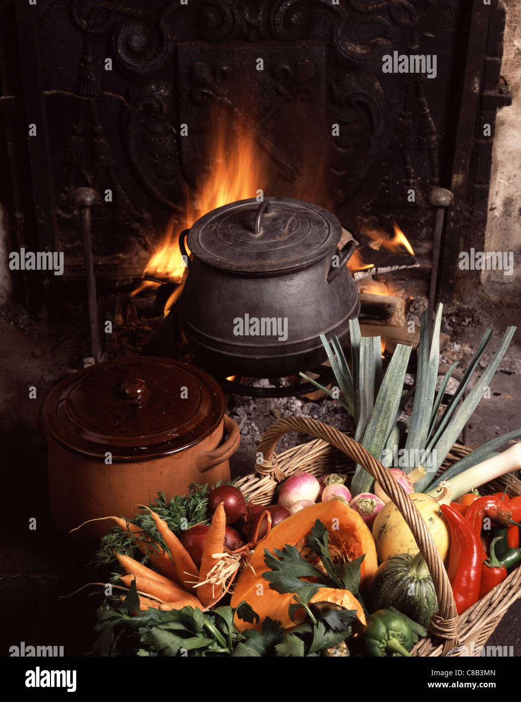Cauldron in fireplace with basket of vegetables Stock Photo Alamy