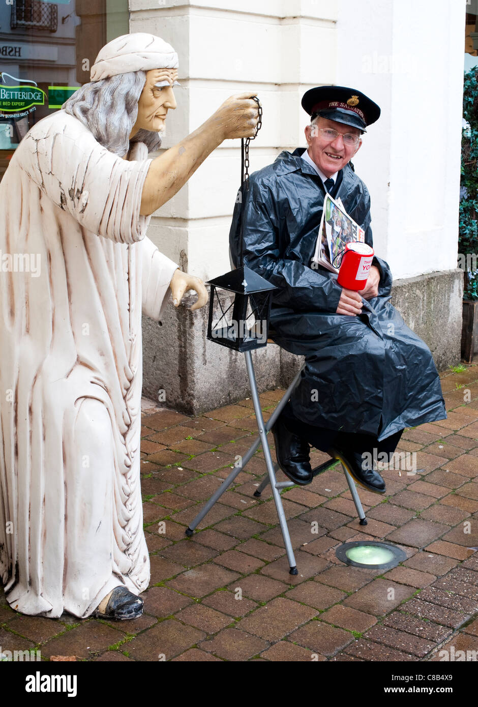 Salvation Army collector with statue in Honiton Devon England Stock Photo