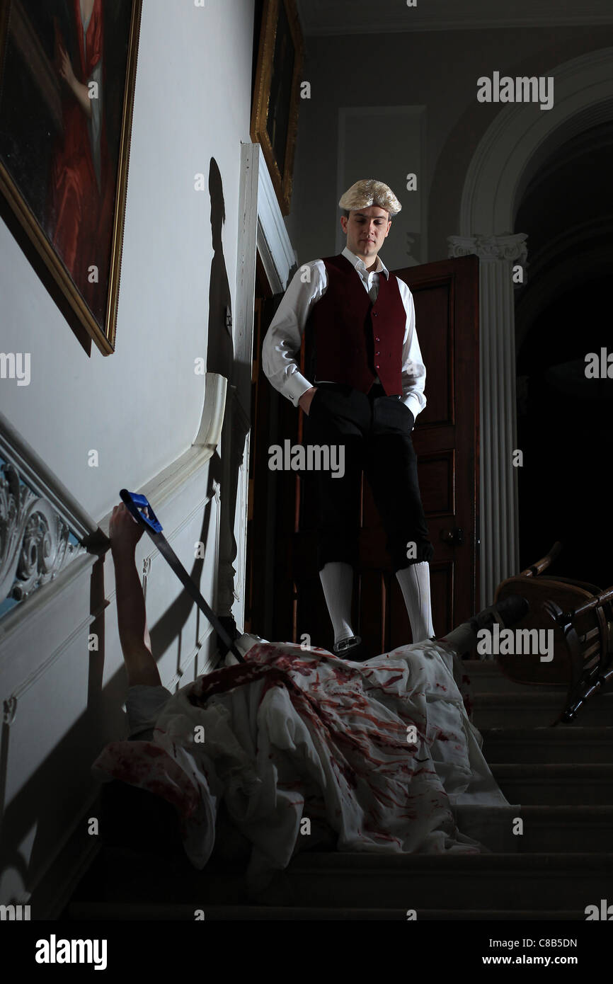 A man dressed as a butler views a staged accident during a Halloween festival Stock Photo