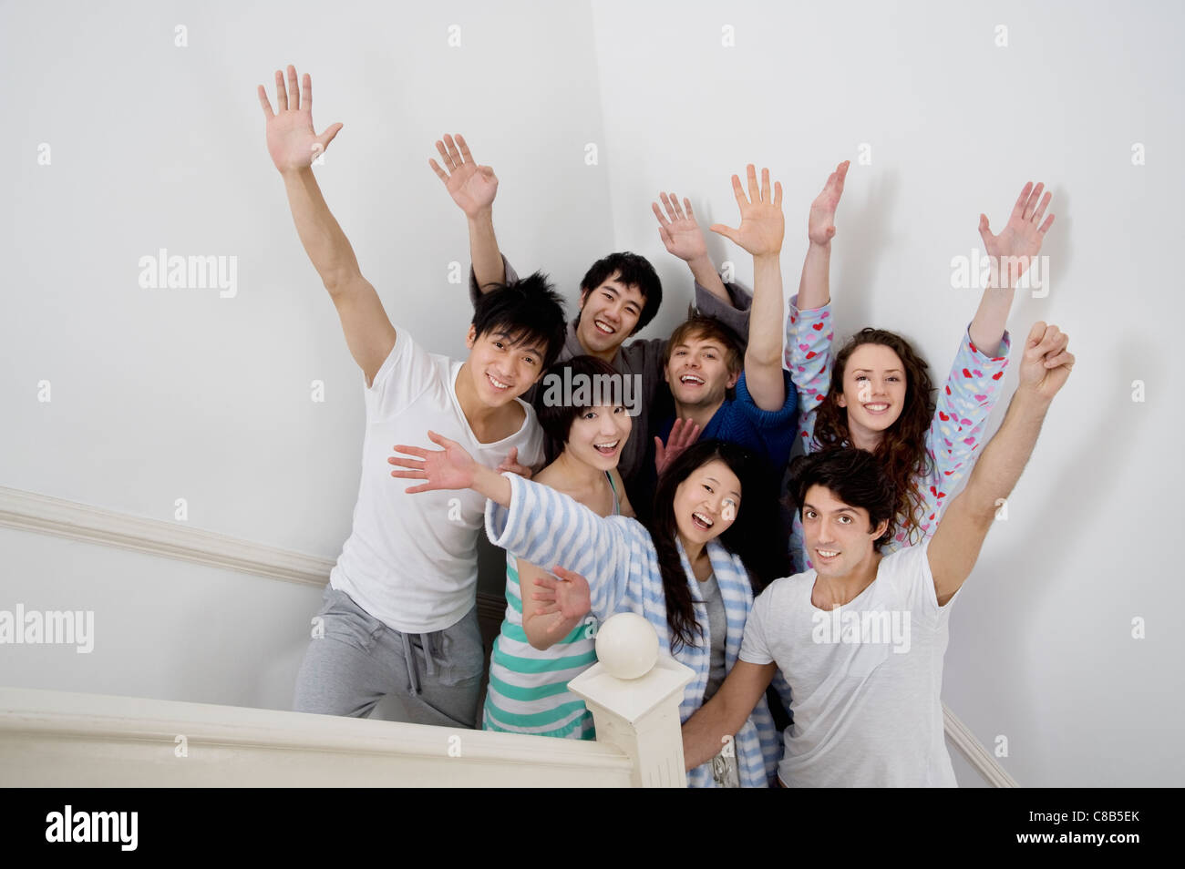 Group of young friends raising arms Stock Photo