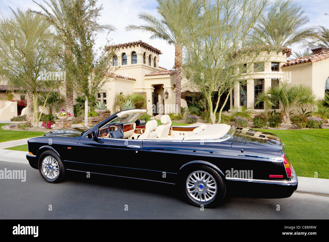 Black convertible car parked in front f luxury house Stock Photo