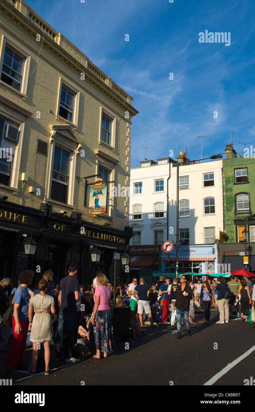 Corner of Elgin Crescent and Portobello Road streets on busy Saturday market day Notting Hill district London England UK Europe Stock Photo