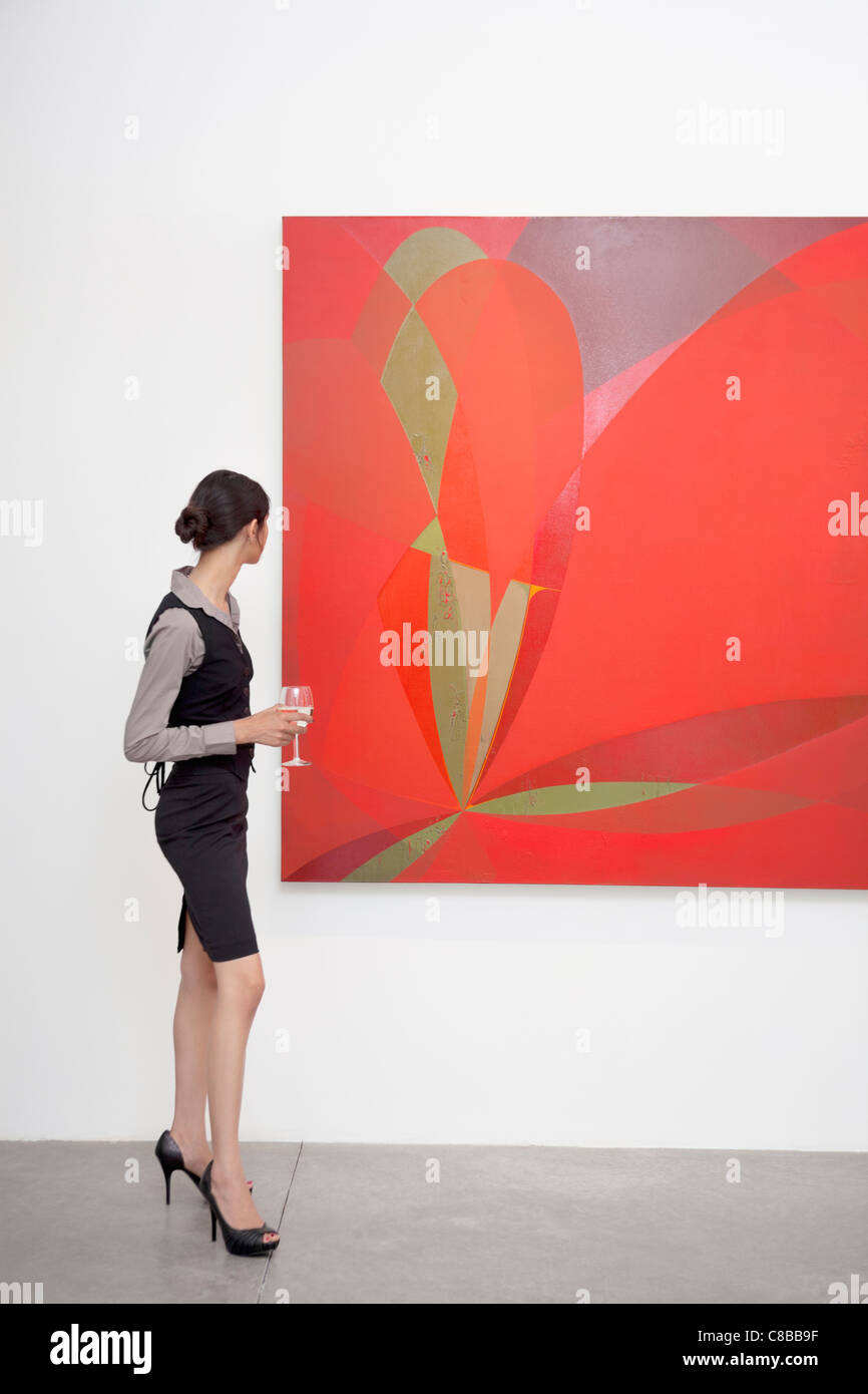 Full length of a woman looking at painting in art gallery Stock Photo