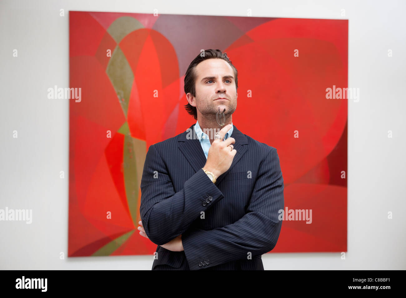 Young Adult Man Thinking In Front Of Painting In Art Gallery Stock Photo Alamy