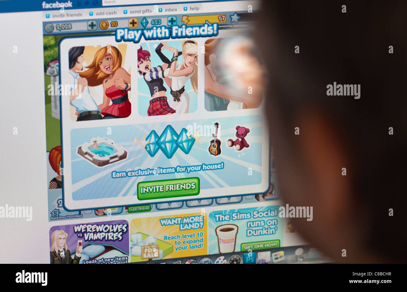 A woman plays the popular Sims Social game on the Facebook social networking website Stock Photo