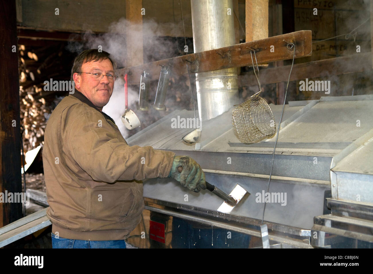 Worker boiling maple sap in a sugar shack at Lake Odessa, Michigan, USA. Stock Photo