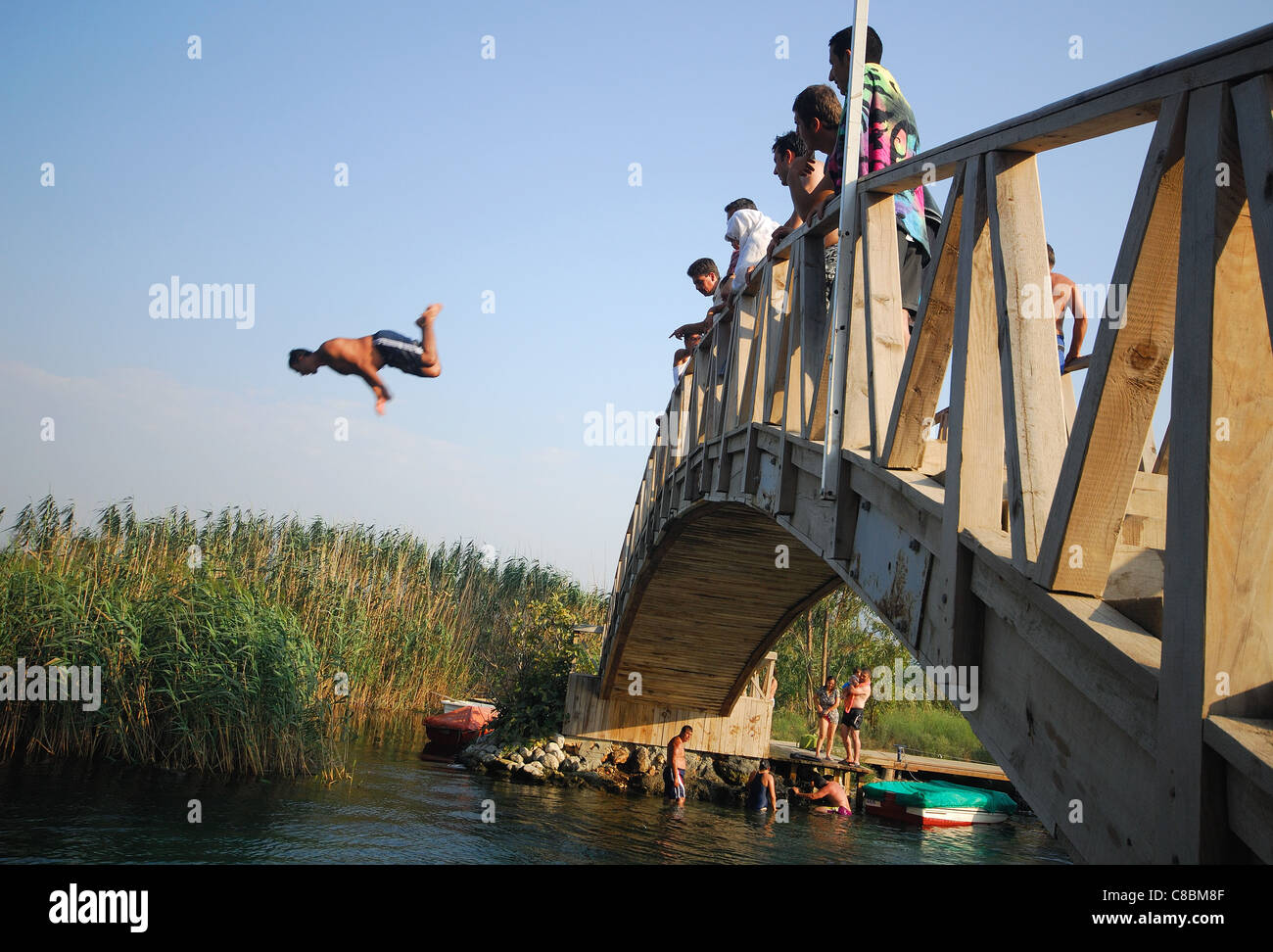 AKYAKA, TURKEY. A man diving off a wooden bridge into the Azmak river. 2011. Stock Photo