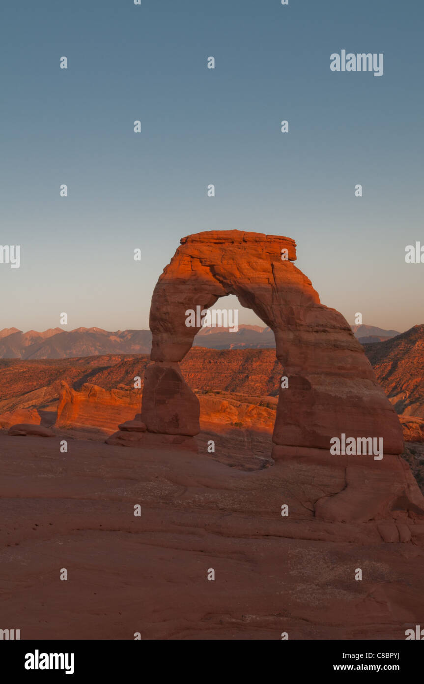 Delicate arch illuminated by the orange glow of sunset. Stock Photo