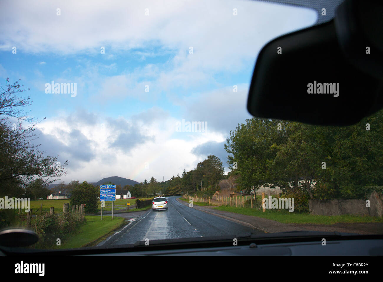 Strathlinnhe Holiday Homes, situated in the beautiful Scottish Highlands, Scotland driving through village small rainbow over Stock Photo
