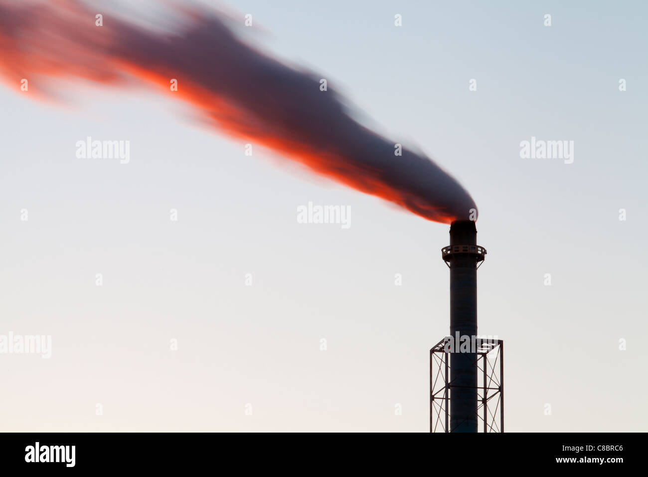 Dawn view of smoke billowing from a smokestack. Stock Photo