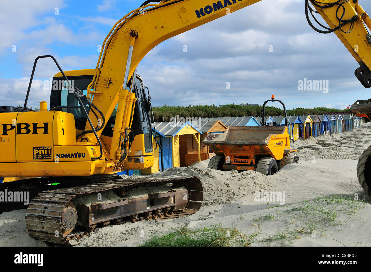 Tractors and diggers removing the encroaching 'moving 'sand dunes in