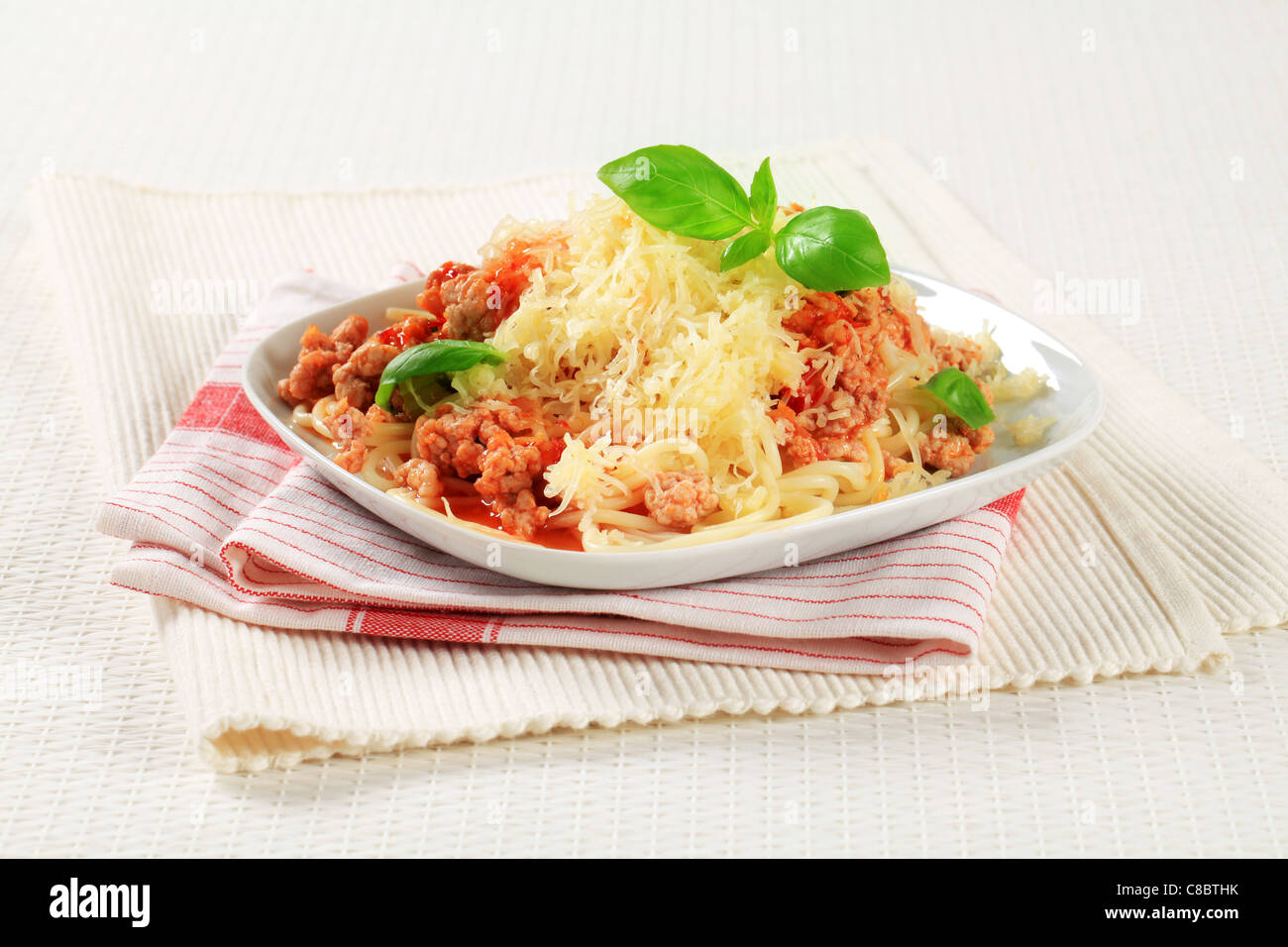 Spaghetti with minced meat and tomato sprinkled with cheese Stock Photo