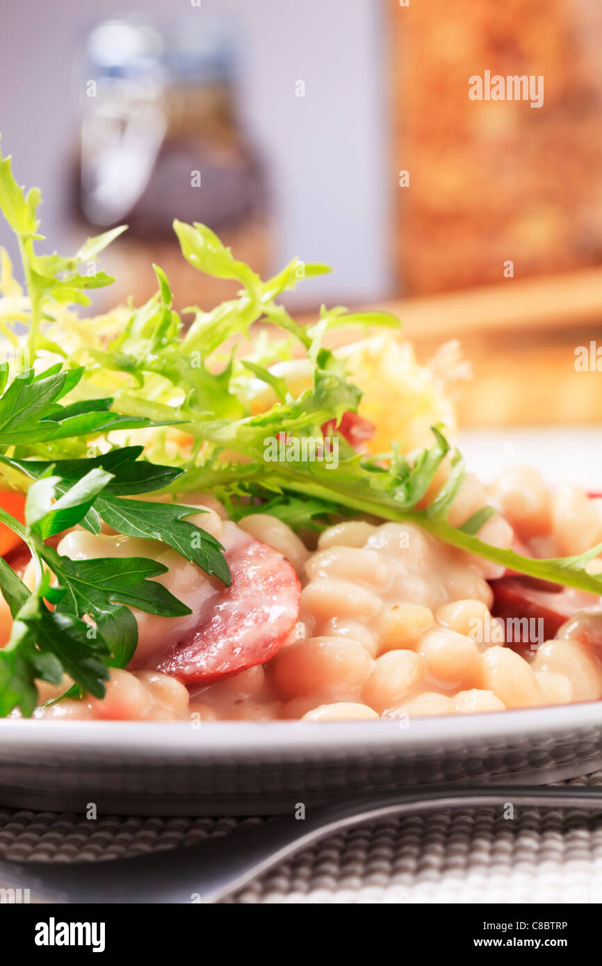 White beans and sausage garnished with greens Stock Photo