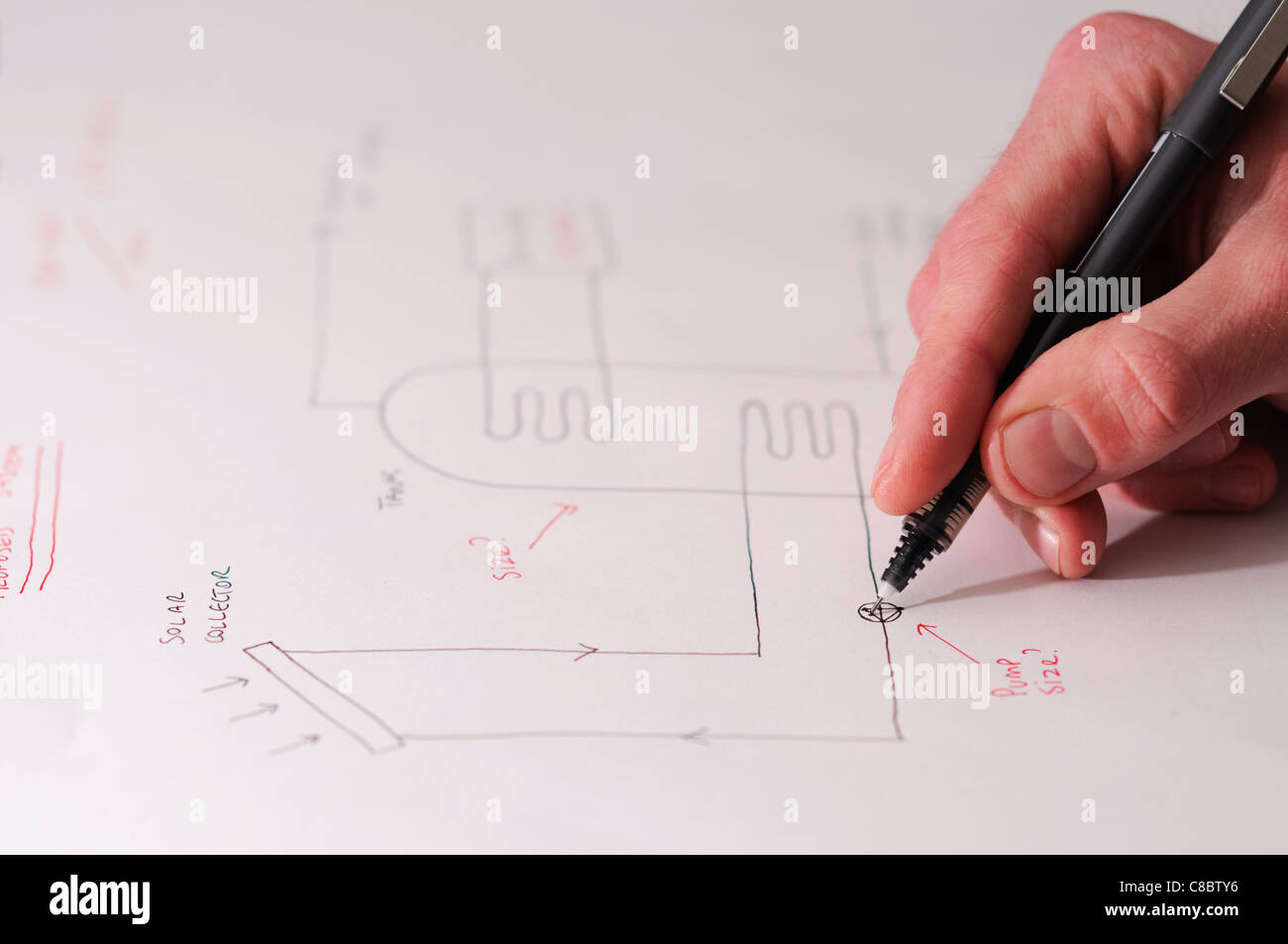An engineer puts the finishing touches to a schematic for a solar thermal hot water system. Stock Photo