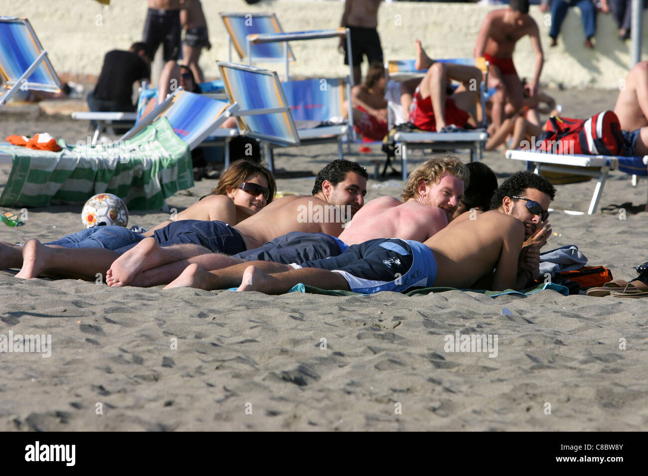young people sunbathing Ostia beach Italy Stock Photo