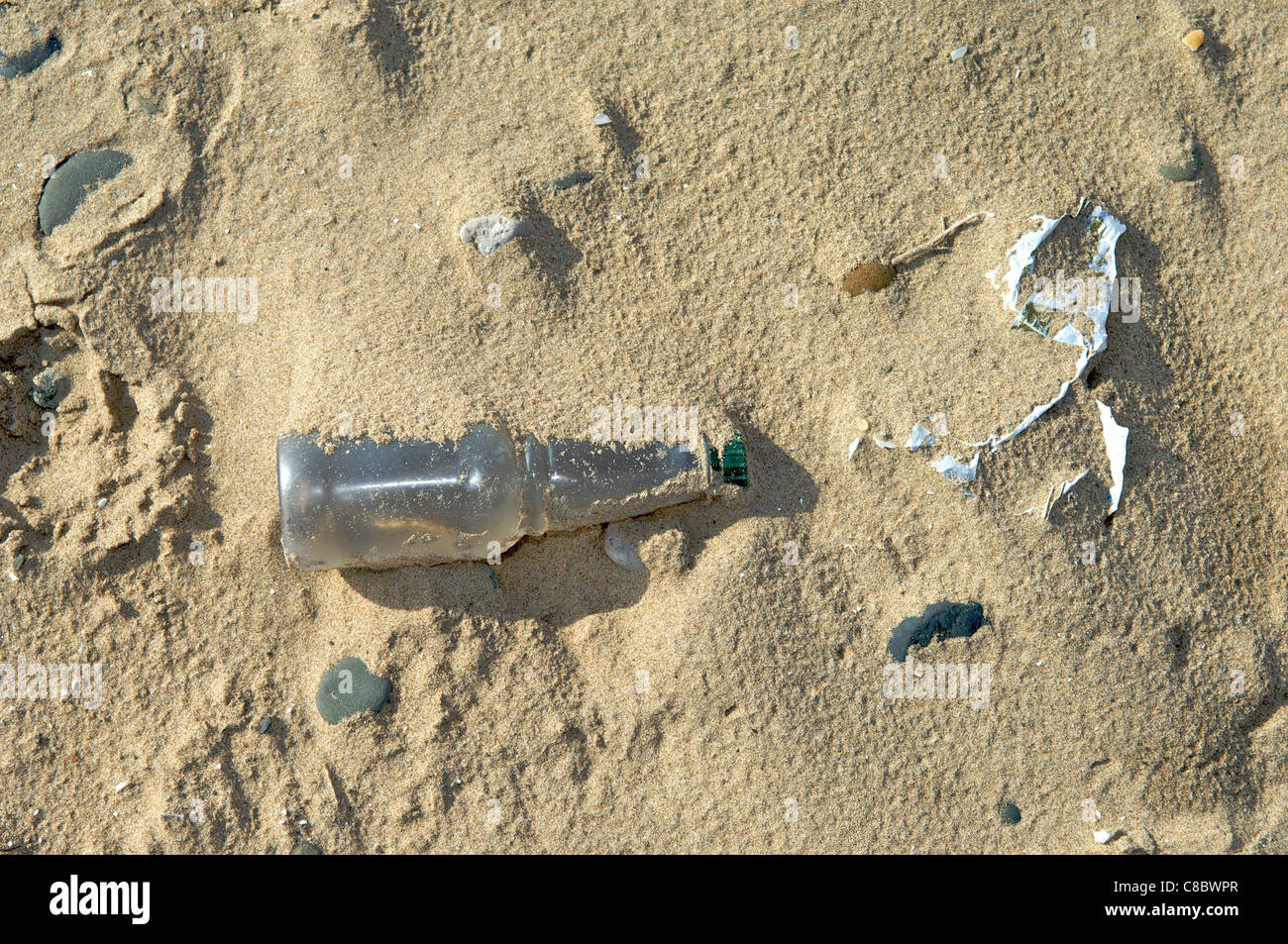 Plastic bottle and other rubbish discarded on beach Stock Photo