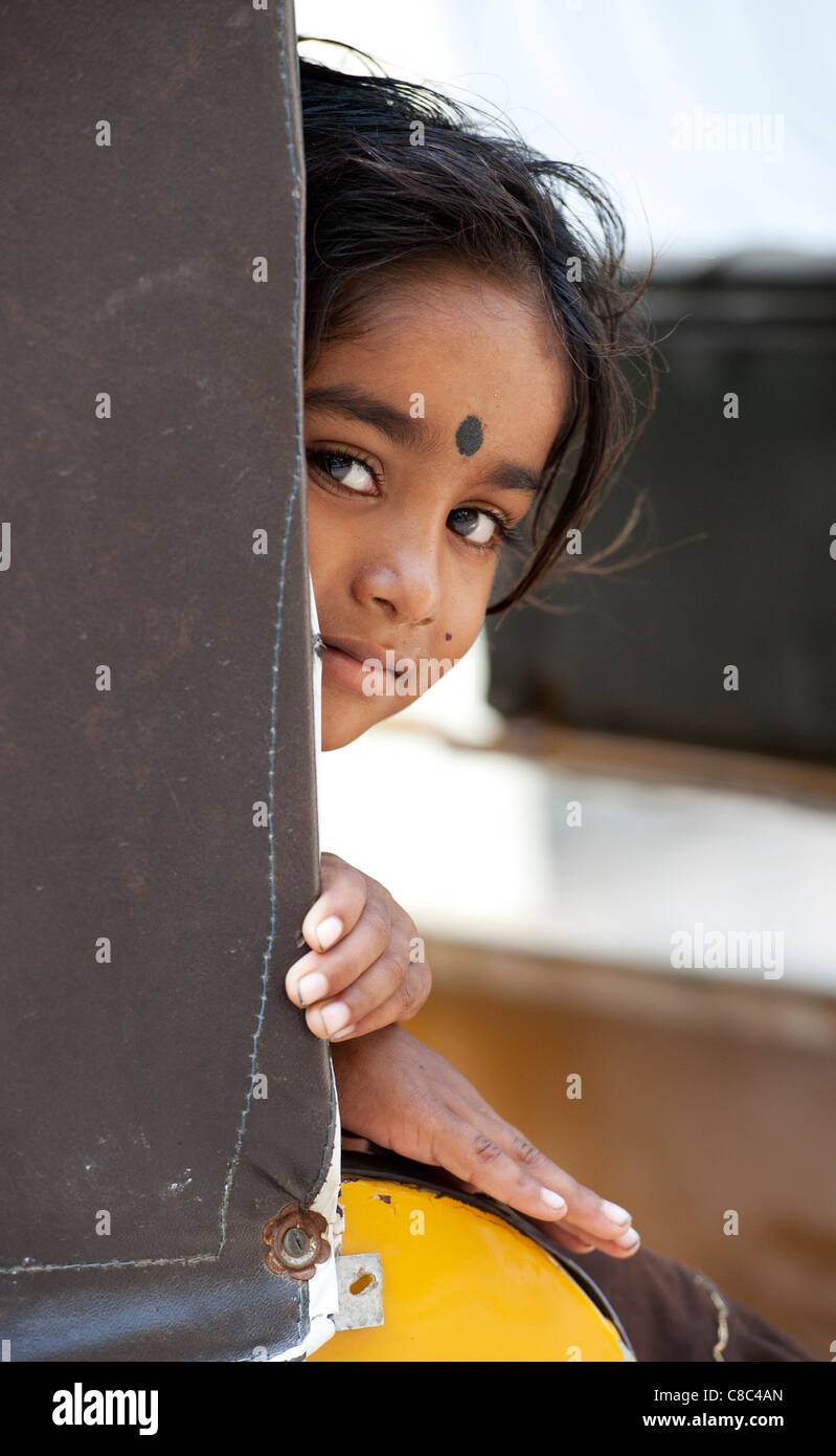 Happy young poor lower caste Indian street girl playing inside an Indian rickshaw. Selective focus Stock Photo