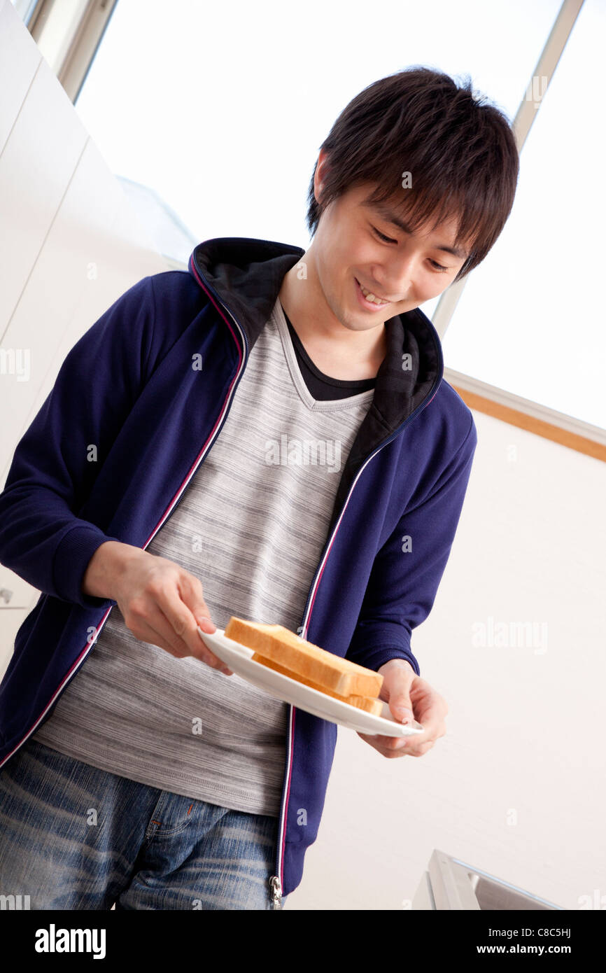 Young man holding plate of toast Stock Photo