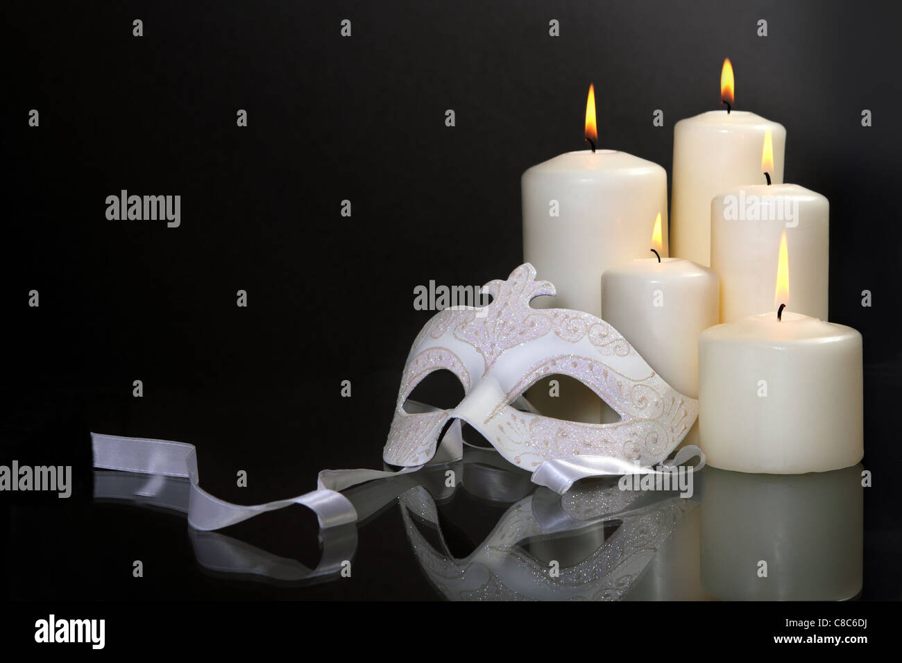 Group of candles and carnival mask over black background Stock Photo