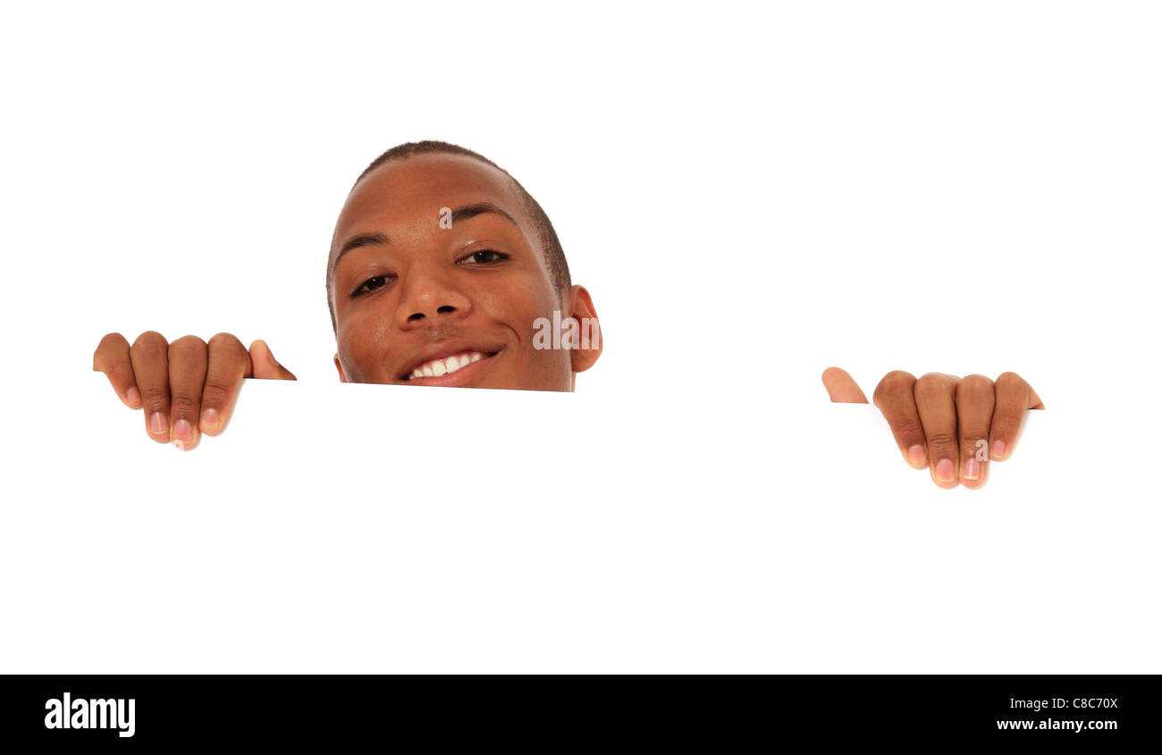 Attractive black man hiding behind white wall. All on white background. Stock Photo