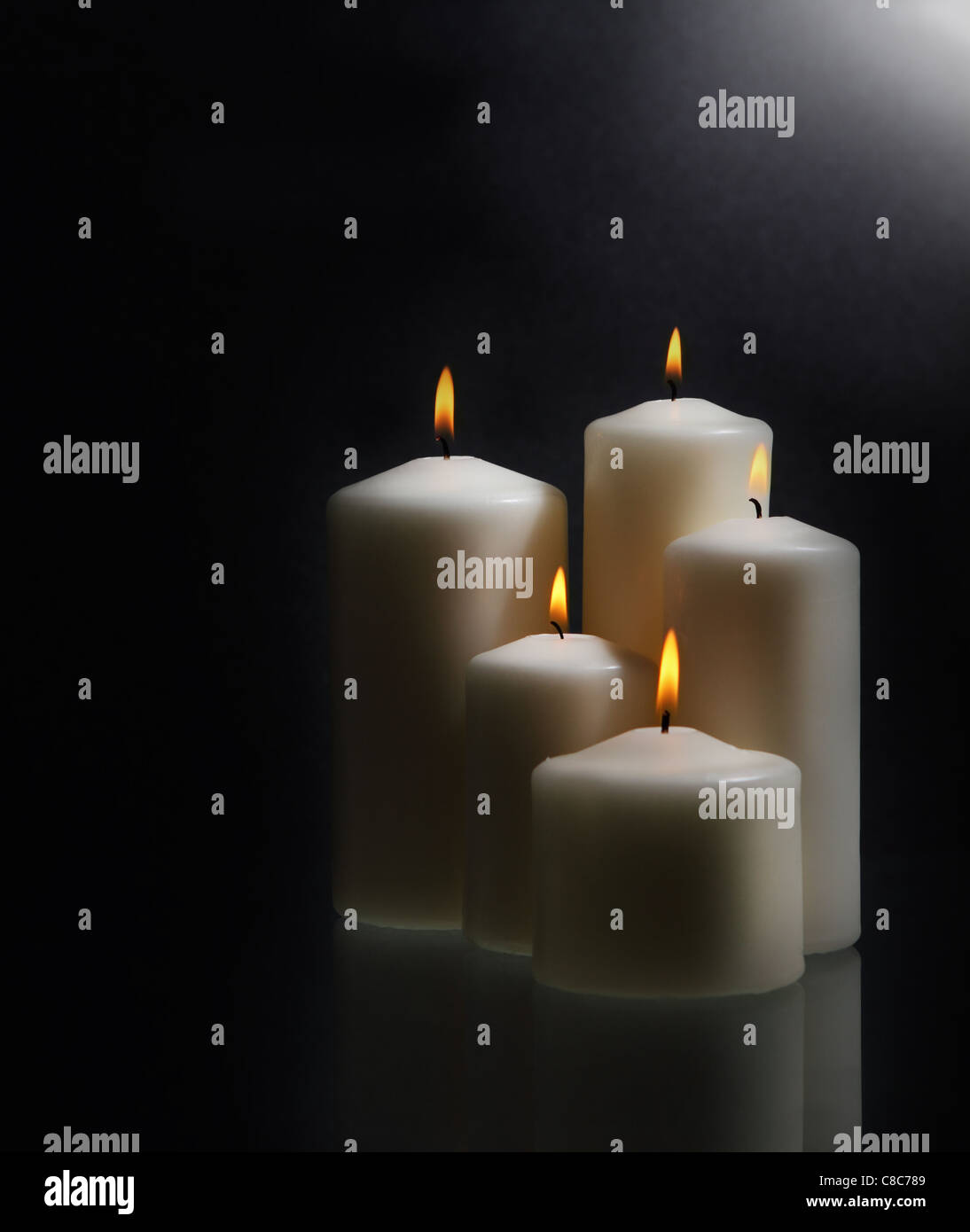 Group of white burning candles over black background Stock Photo - Alamy