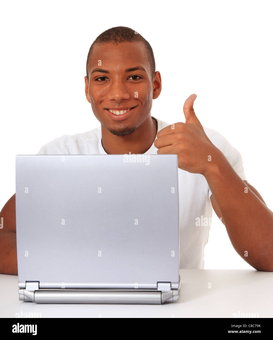Attractive black guy showing thumbs up while using laptop. All on white