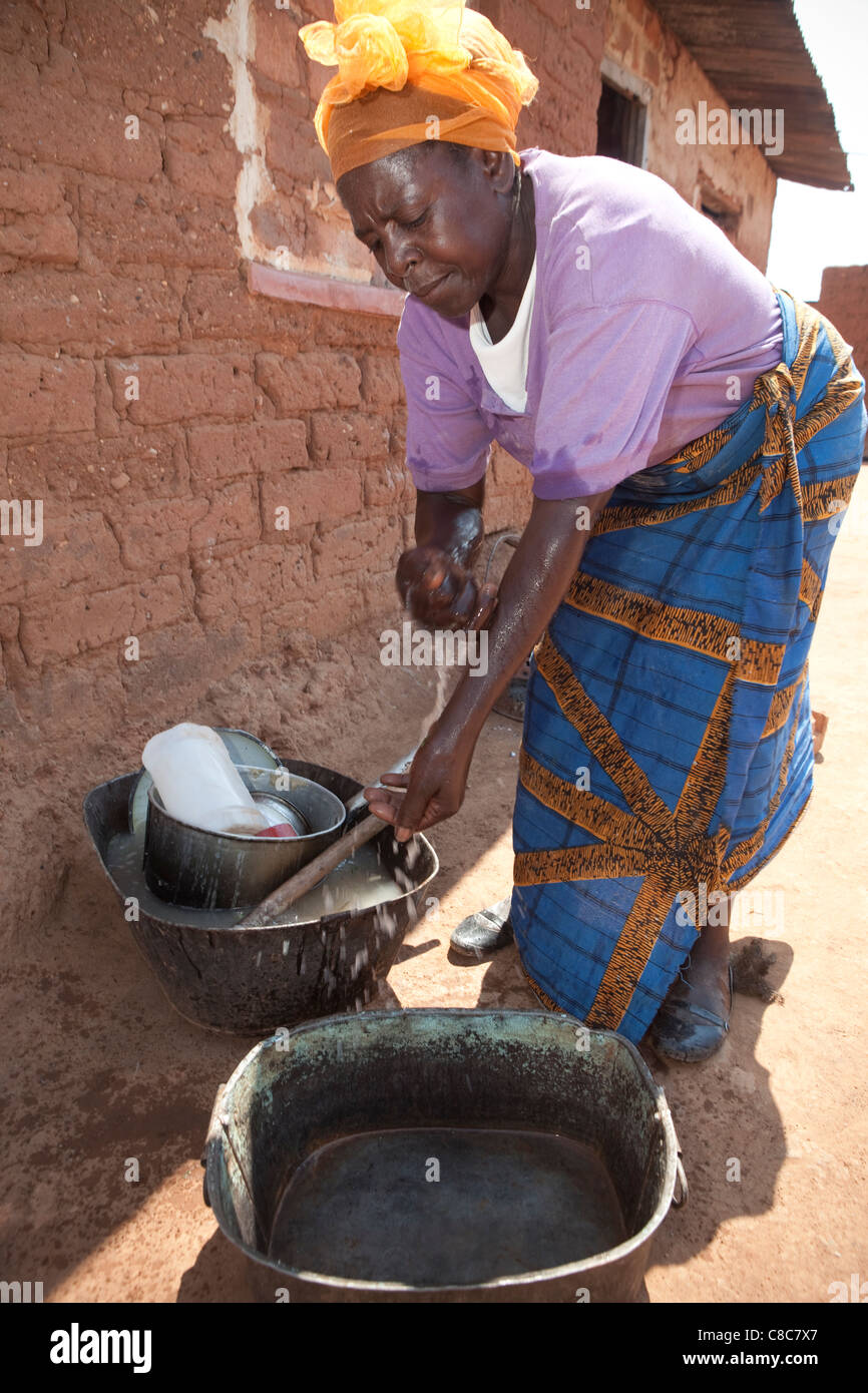 A woman washes her hands outside her home in Mongu, Zambia, Southern Africa. Stock Photo