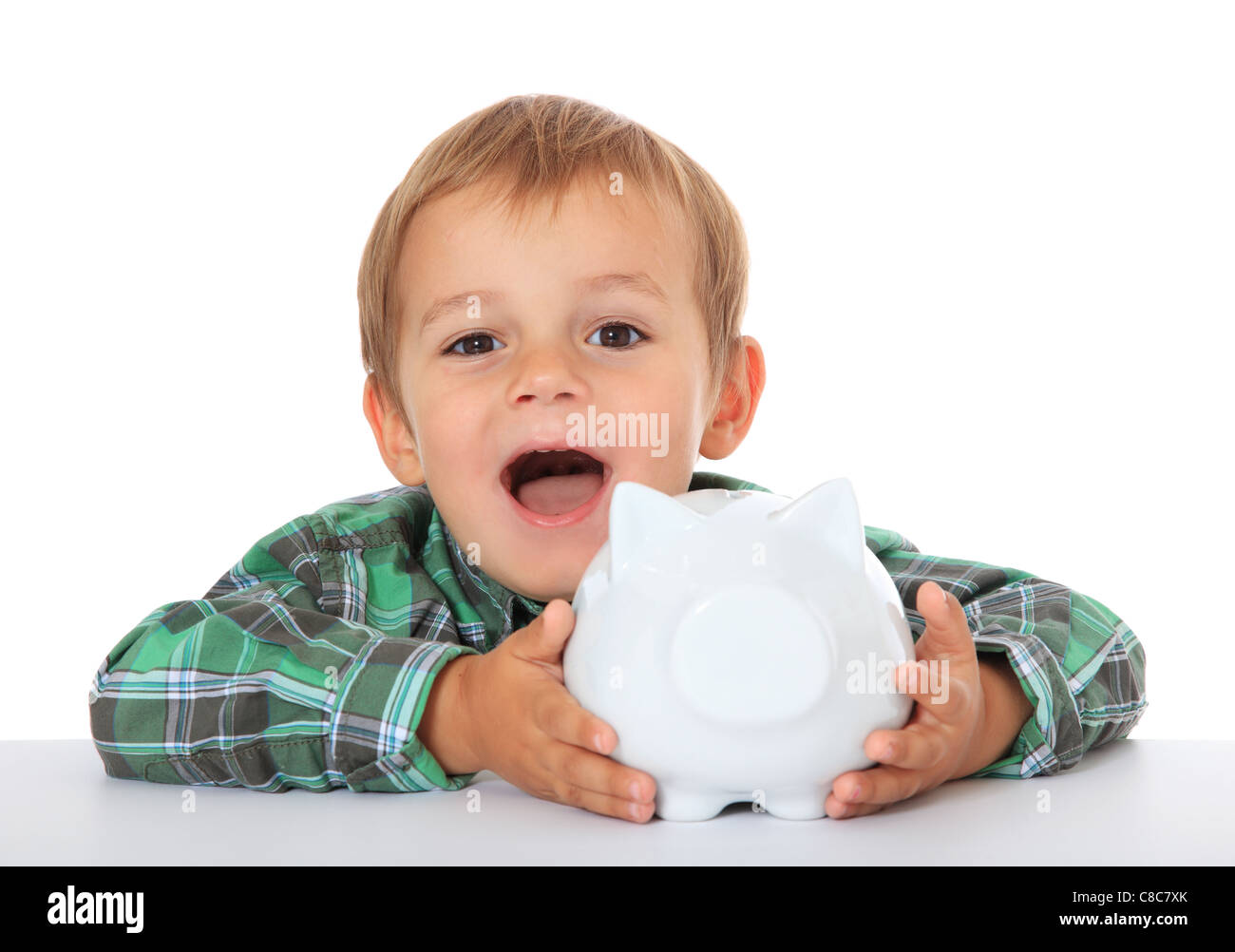 Cute caucasian boy with his piggy bank. All on white background. Stock Photo