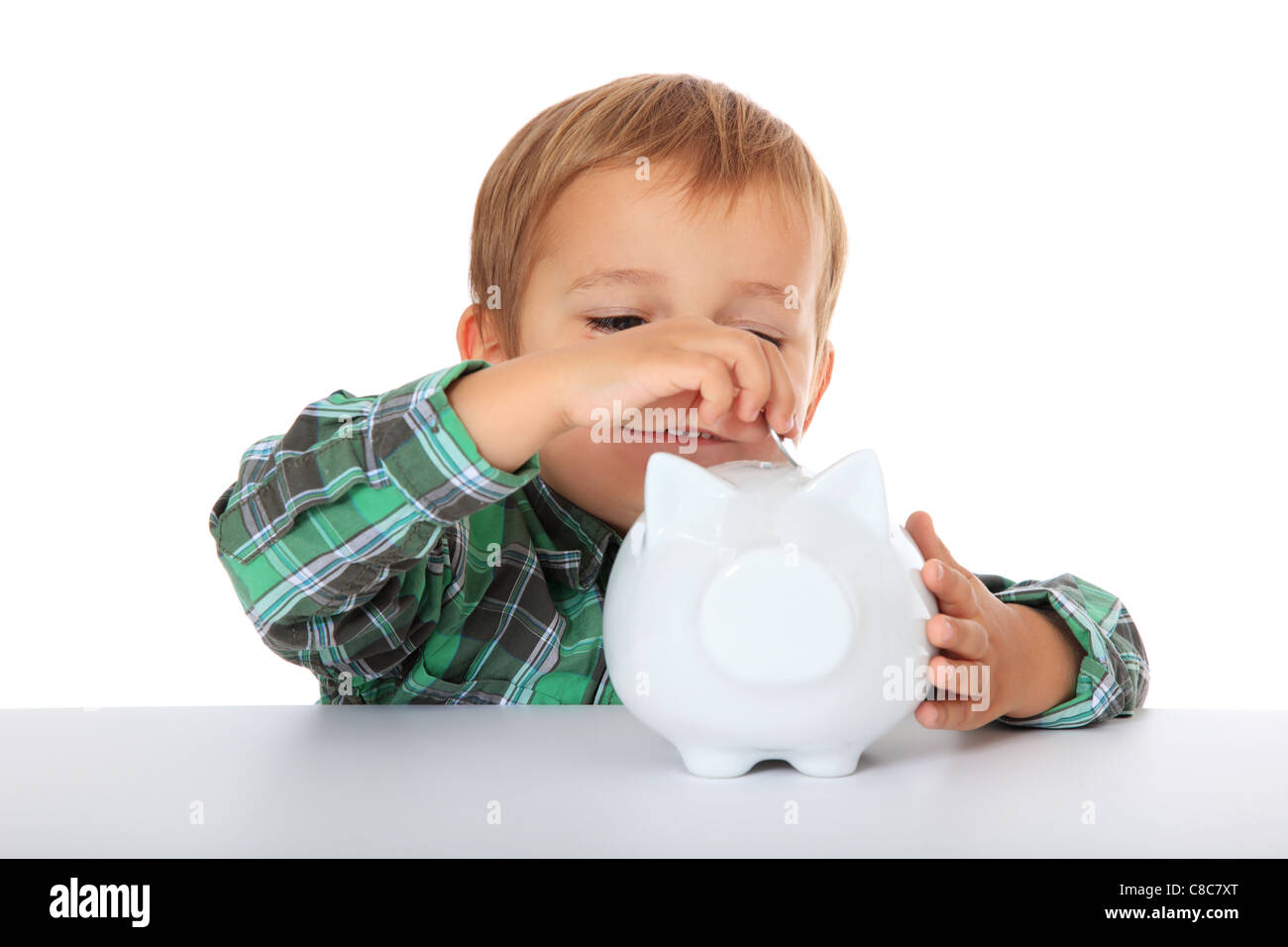 Cute caucasian boy with his piggy bank. All on white background. Stock Photo